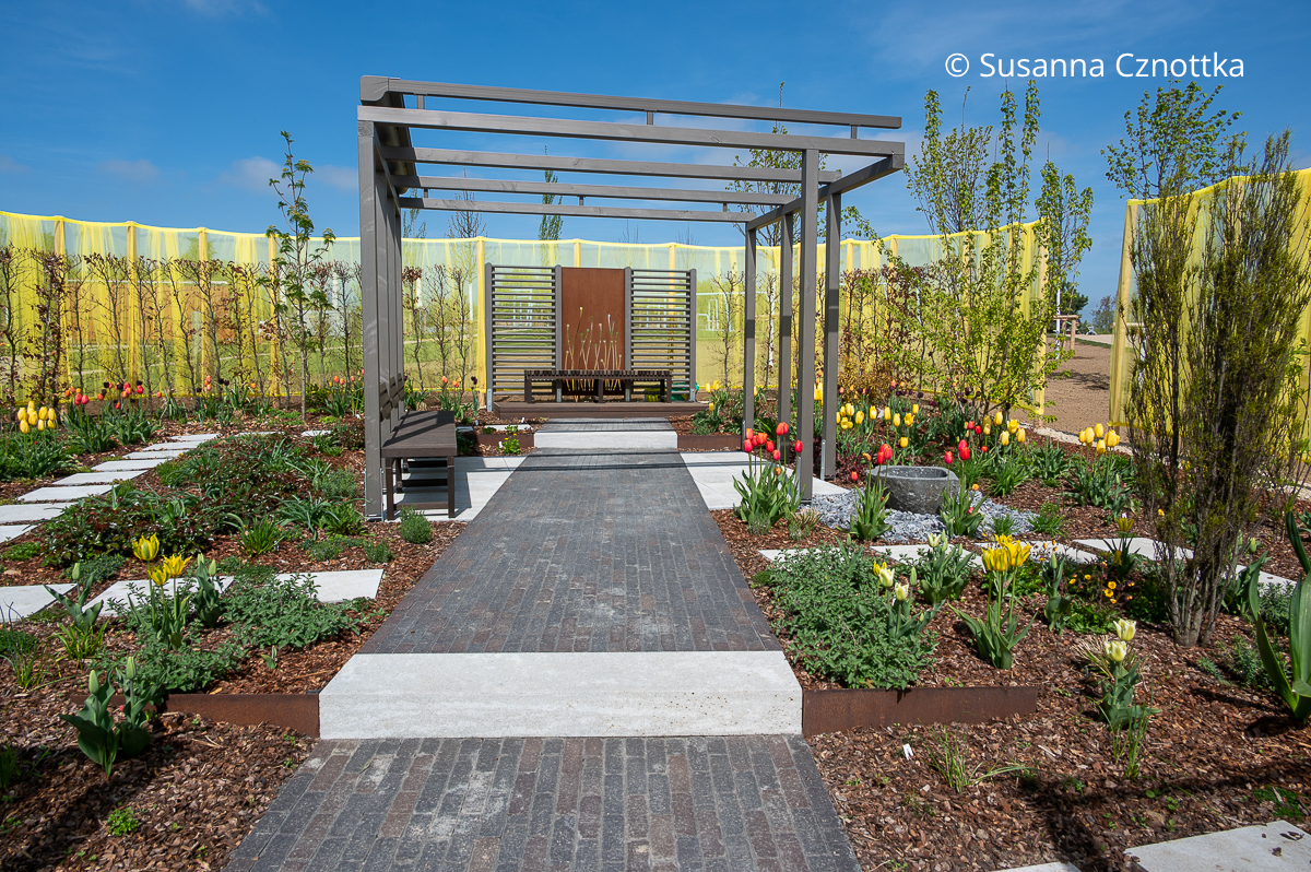 Ein Schaugarten mit Sichtachse und Pergola im Frühling Ein Schaugarten mit Sichtachse und Pergola im Frühling