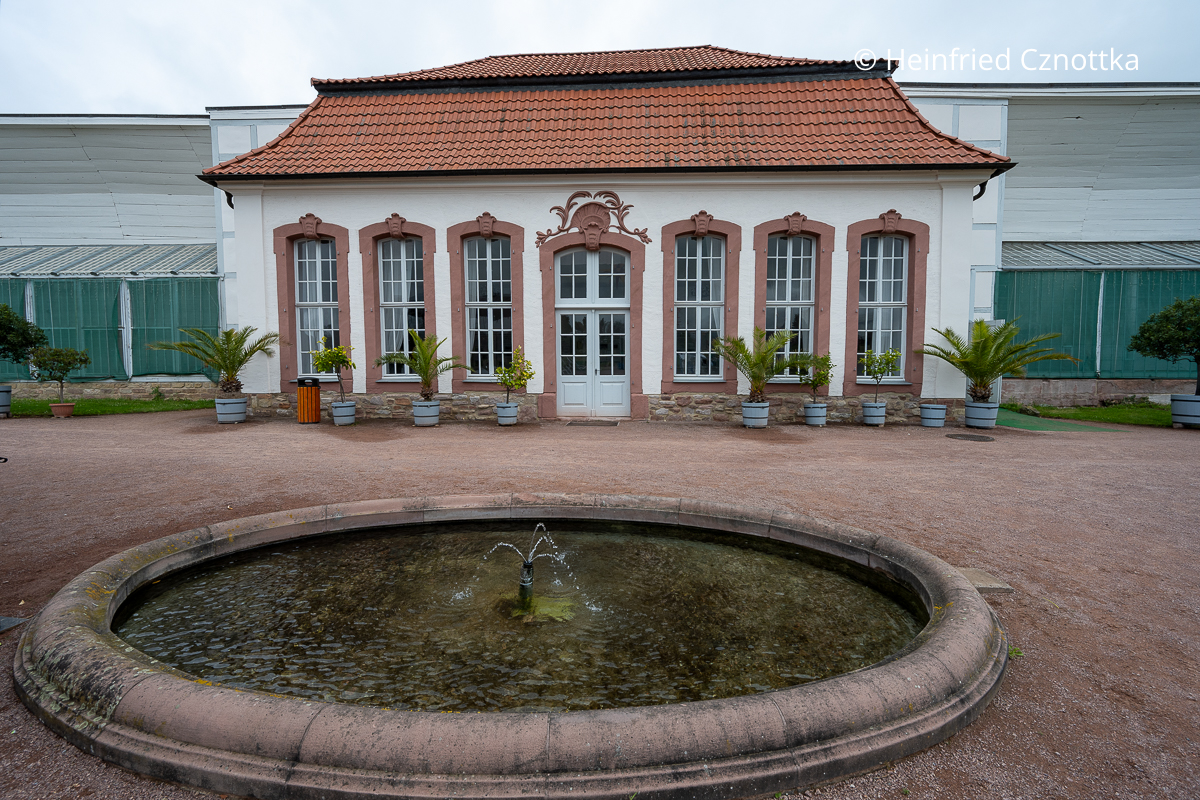 Die historische Orangerie im Barockdorf Bendeleben in der Region Südharz/Kyffhäuser mit einem runden Brunnen davor