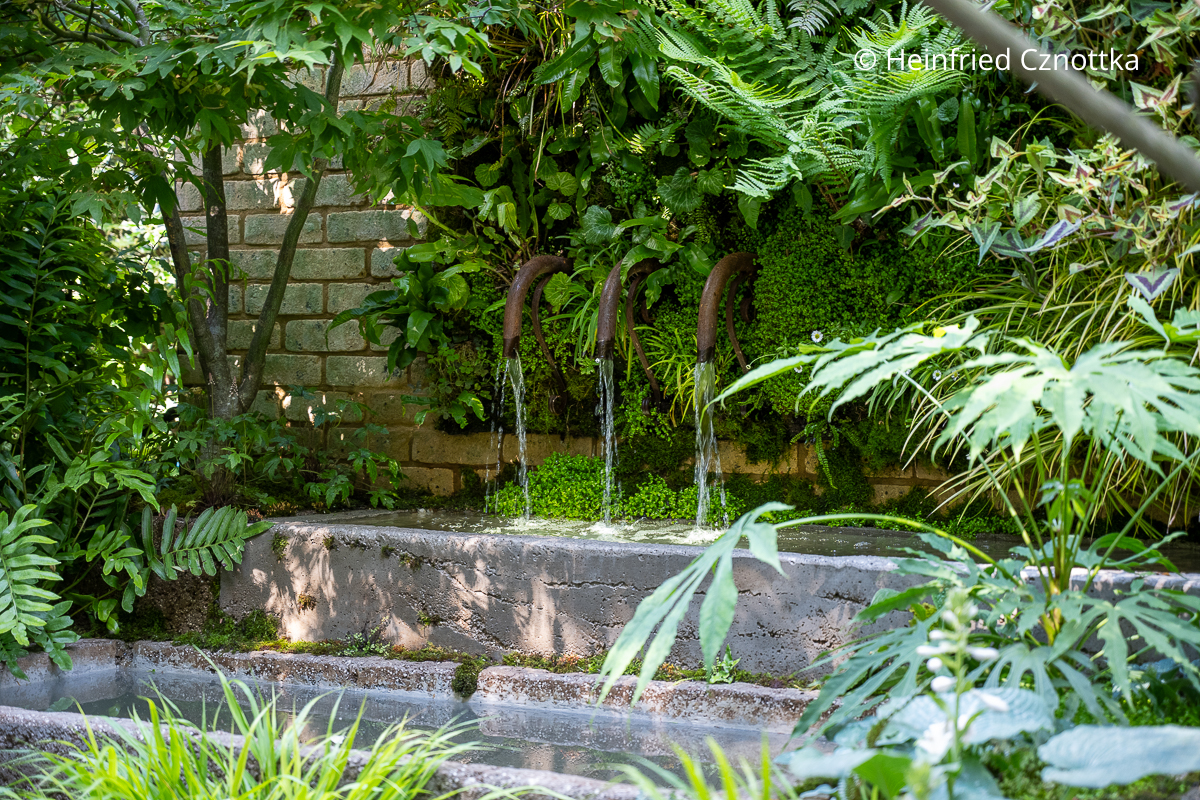 Antike Wasserauslässe speisen die Wasserbecken im kleinen Garten