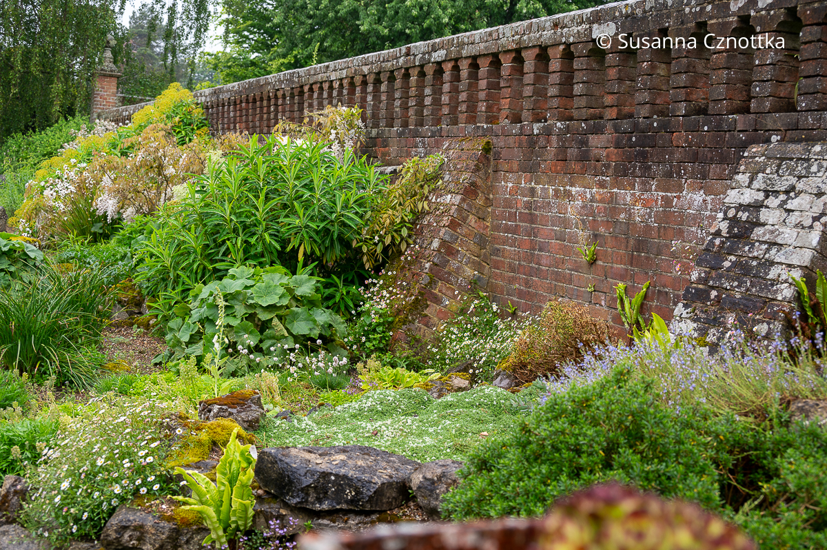 Eine Mauer grenzt den Steingarten vom formalen Garten ab.