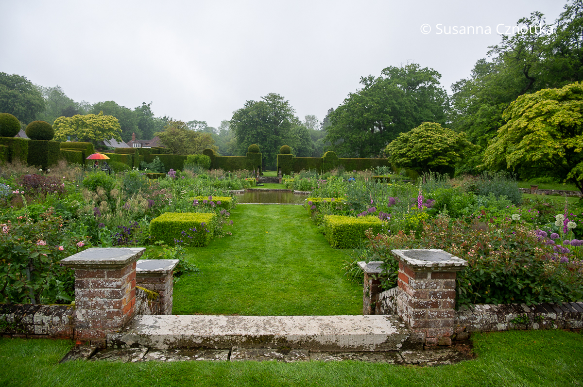 Senkgarten mit einem Wasserbecken im Garten von Doddington Place, umgeben von hohen Ebenhecken