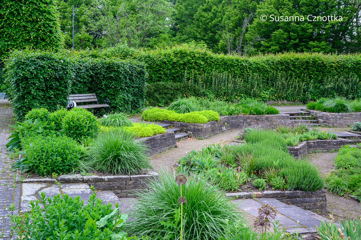 Terrassenförmige Beete um einen Senkgarten