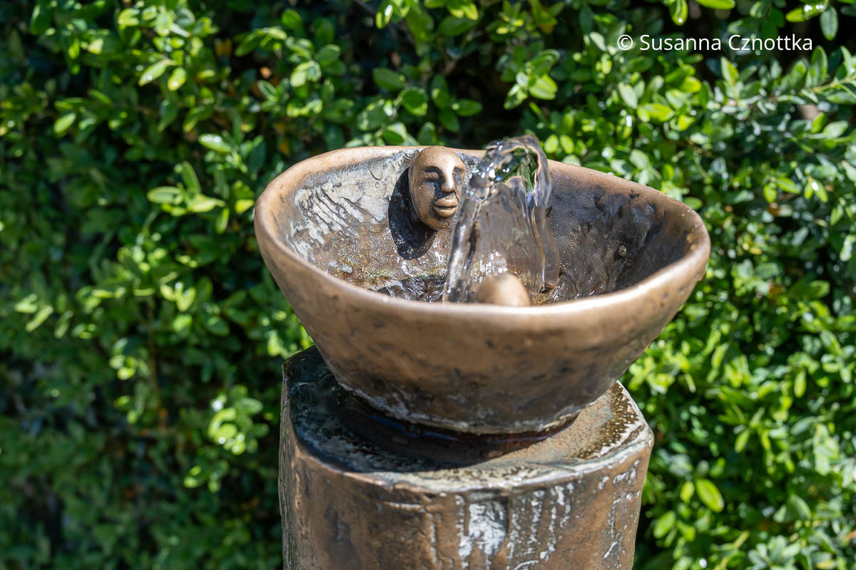Ein kleiner Trinkbrunnen im Giardino di Boboli Ein kleiner Trinkbrunnen, vermutlich aus Bronze, mit einem kleinen plastischen Gesicht an der hinteren Seite der Schale im Giardino di Boboli