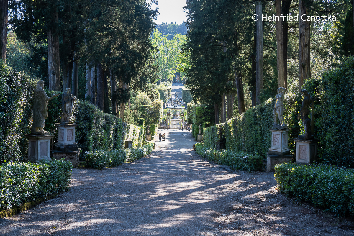 Sichtachse im Giardino di Boboli Sichtachse im Giardino di Boboli mit Hecken, mediterranen Bäumen und antiken Statuen zu beiden Seiten, im Hintergrund ein Brunnen