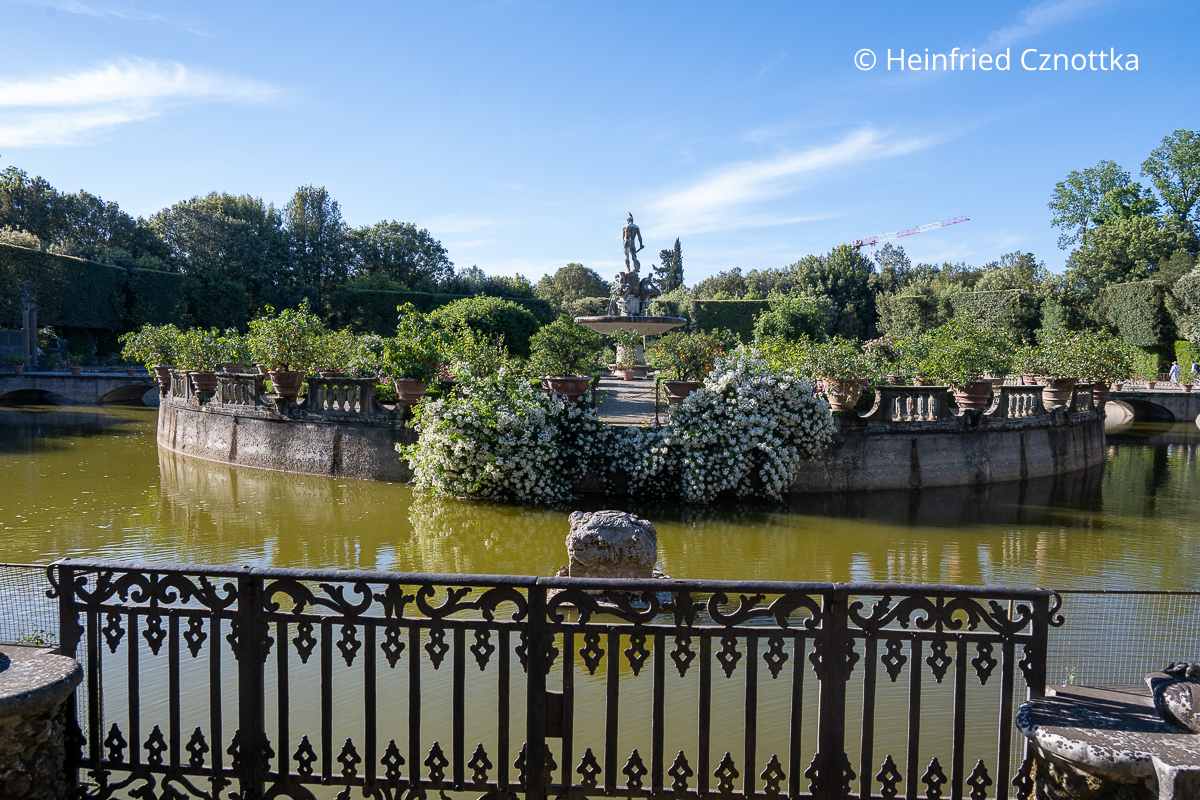 Eine künstliche Insel in einem großen Wasserbecken Eine künstliche Insel in einem großen Wasserbecken, von einer niedrigen Balustrade eingefasst und mit Rosen und bepflanzten Terracottatöpfen geschmückt
