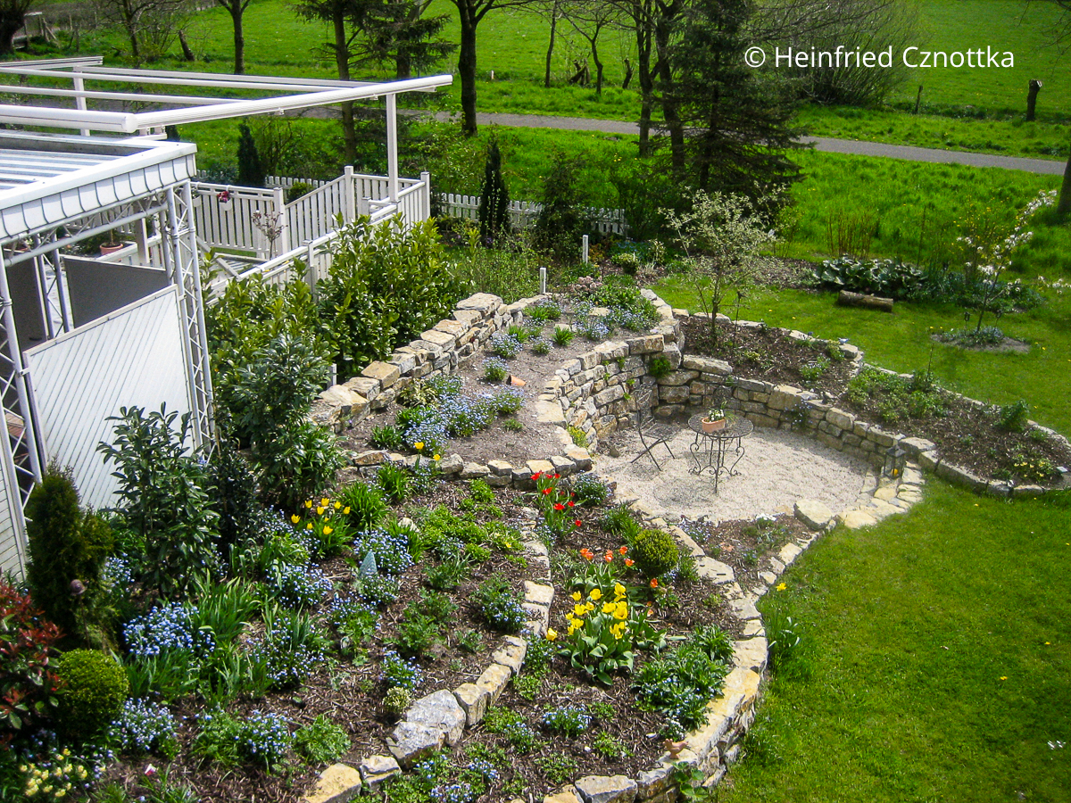 Beete und ein Senkgarten mit Natursteinmauern