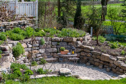 Mauern im Garten: Sitzplatz vor einer Natursteinmauer