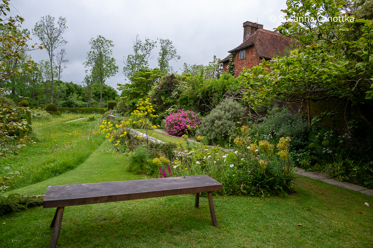 Eine schlichte Holzbank überlässt den Pflanzen die Bühne (Great Dixter House & Gardens)