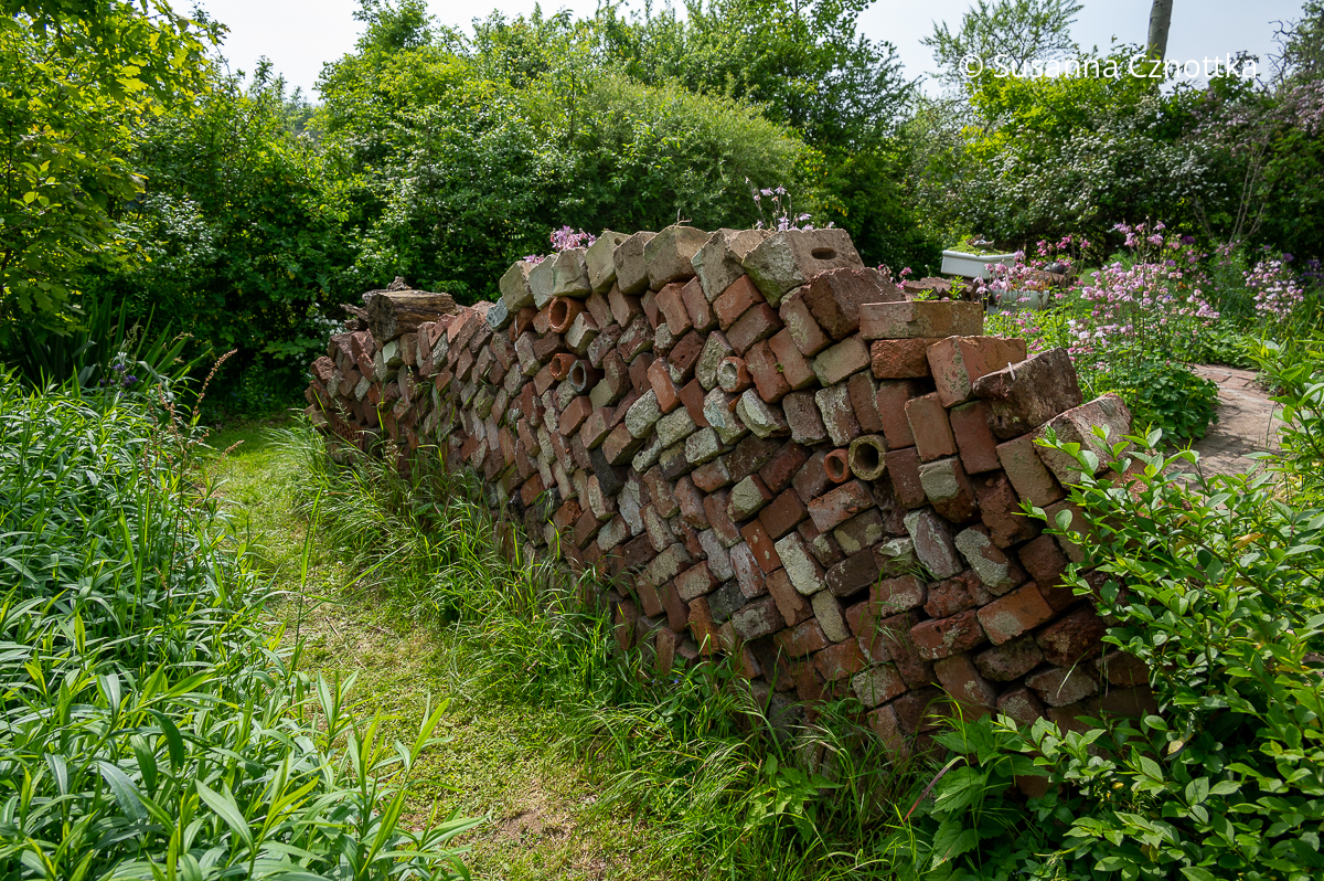 Upcycling im Garten: Mauer aus alten Backsteinen und Tonröhren