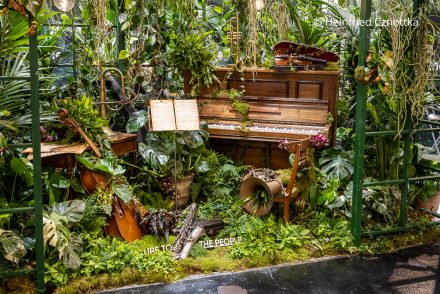 Phantasievoller Messestand auf der Internationalen Pflanzenmesse (IPM) Essen 2026: Musikinstrumente in einem Dschungel im Gewächshaus