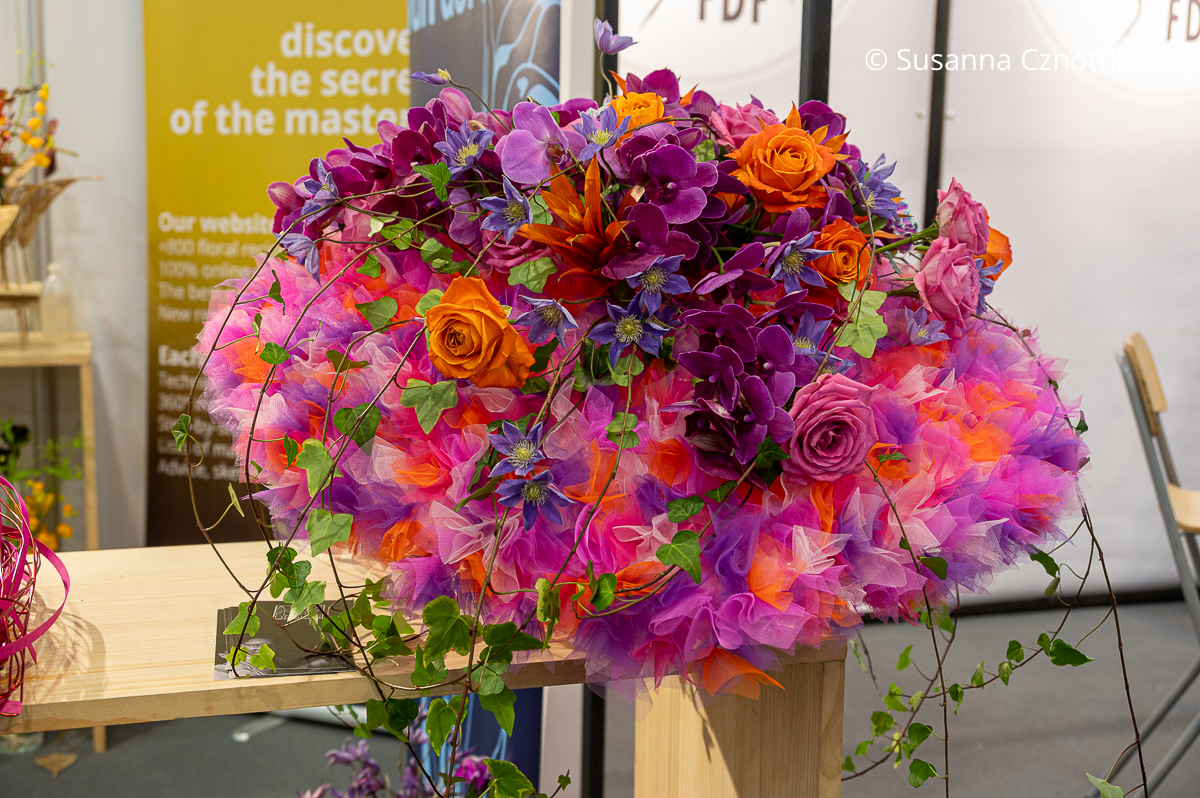 Ein Blumenstrauß in einer Tüllmanschette in Orange und Violett