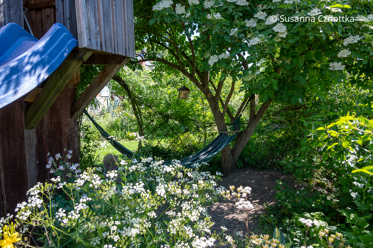 Ein bisschen Bullerbü im Garten für Kinder: Spielhaus, geflochtener Weidenzaun und Hängematte