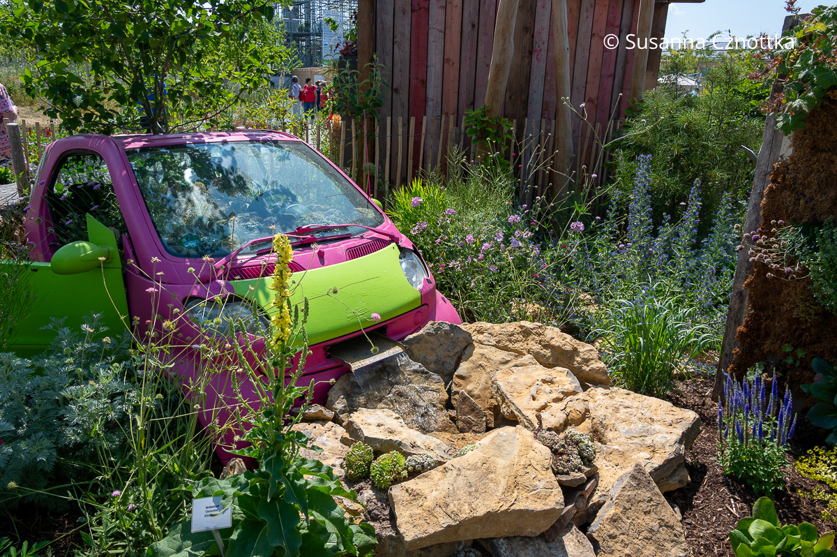 Upcycling im naturnahen Garten: ein bepflanzter Kleinwagen