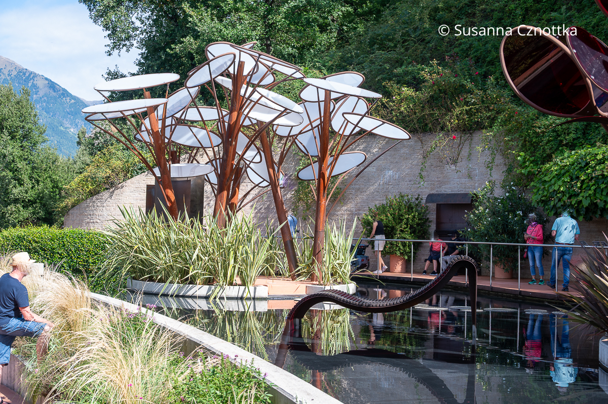 Stilisierte Pflanzen mit weißen runden Blüten auf einer Insel in einem Wasserbecken