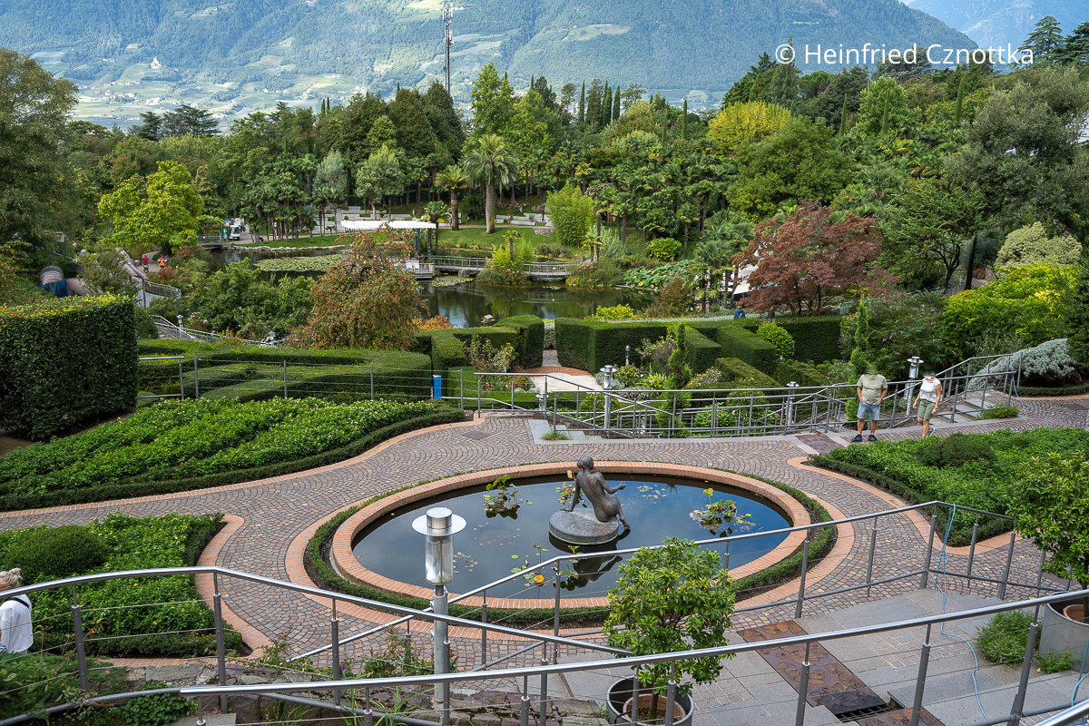 Blick über ein Wasserbecken mit einer Skulptur in den Gärten von Schloss Trauttmansdorff