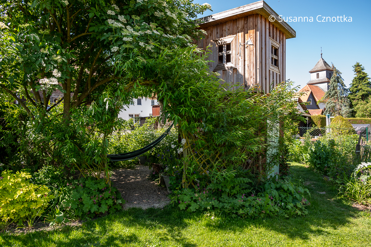 Weidenzaun mit bogenförmigem Durchgang im Garten von Jenny Adam