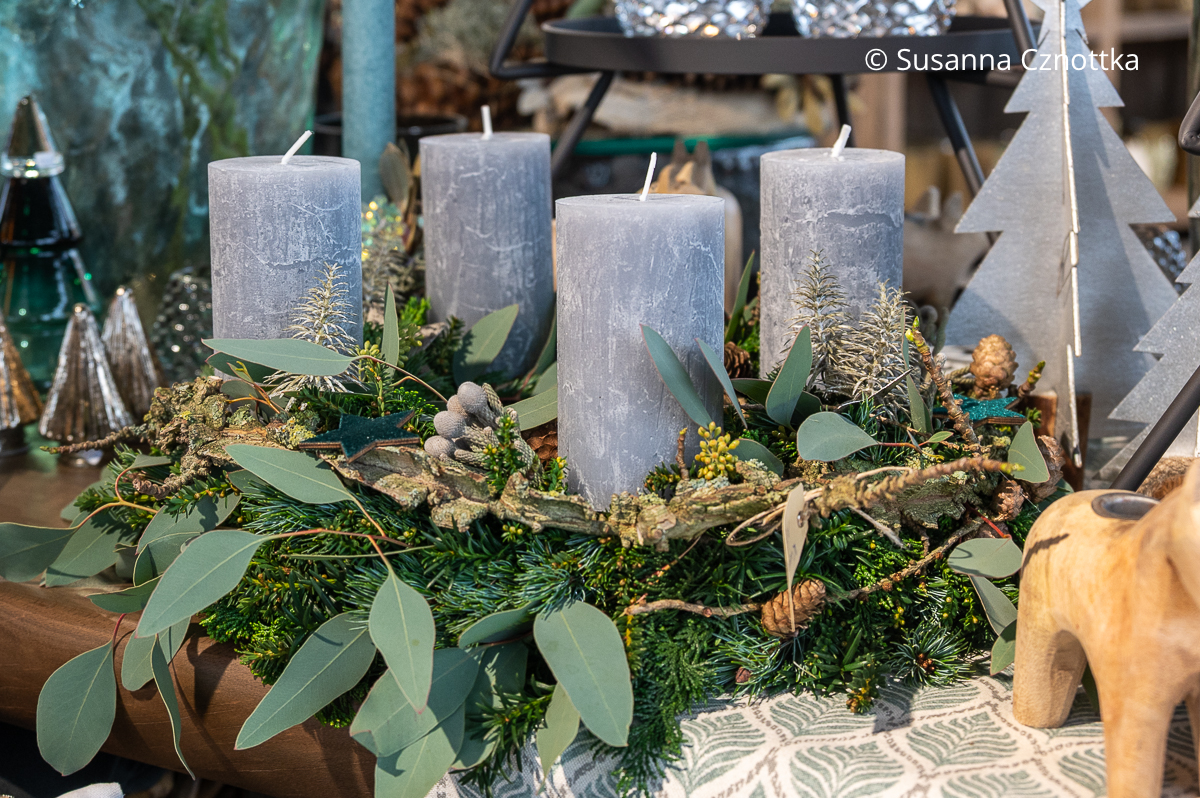 Ein Adventskranz aus Tannengrün mit Eukalyptuszweigen und grauen Kerzen