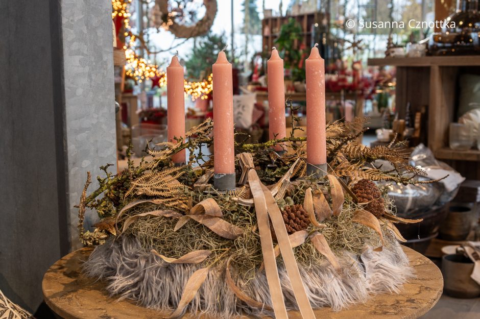 Ein besonderer Adventskranz mit rosa Kerzen und beigen Details mit einer Unterlage aus weichem Fell