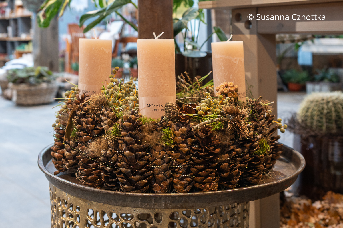 Schlichter Adventskranz aus Zapfen, Bouillondraht und Dattelfrüchten mit beigen Stumpenkerzen