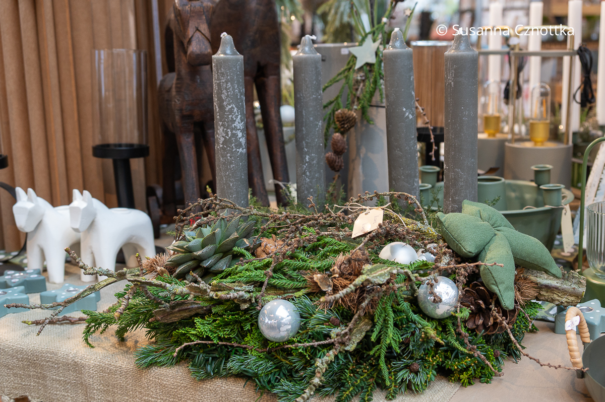 Adventskranz mit grauen Stabkerzen, einer wattierten grünen Schleife und einer Echeverie