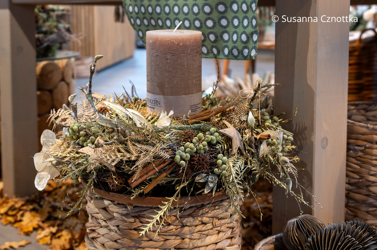 Exotischer Kranz mit Dattelfrüchten, Silberlingen und vergoldetem Farn in Beige- und Brauntönen mit einer dicken beigen Kerze