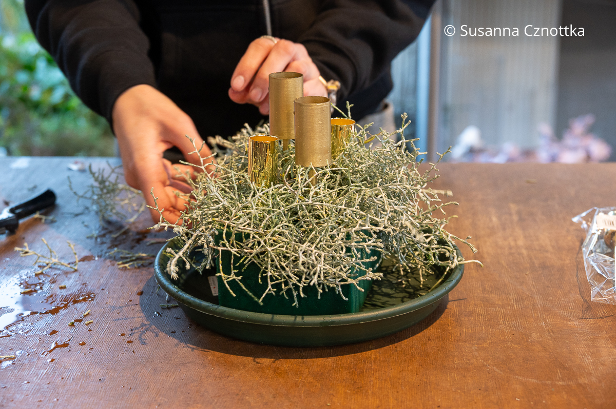 Grundlage für ein Gesteck mit Steckschaum und Stacheldrahtpflanze auf einem grünen Untersetzer