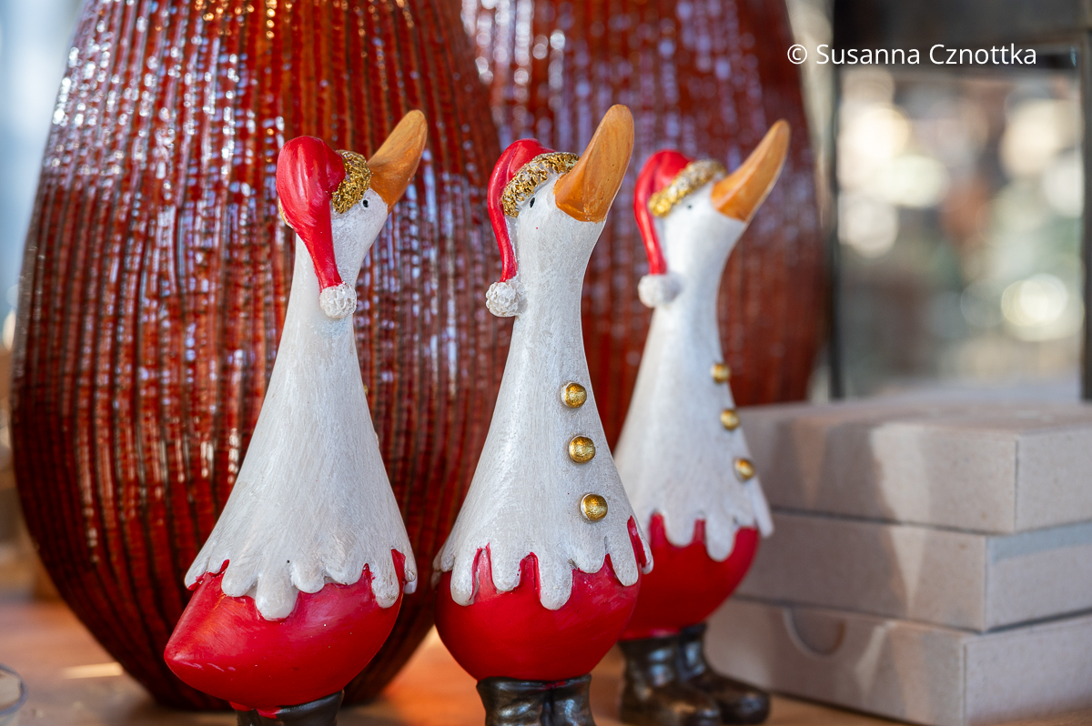 Drei kleine Gänsefigürchen mit Weihnachtsmannmütze 