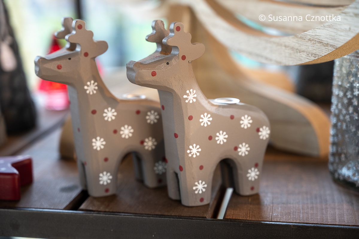 Zwei kleine Rentiere aus Holz, mit weißen Schneeflocken und roten Punkten bemalt