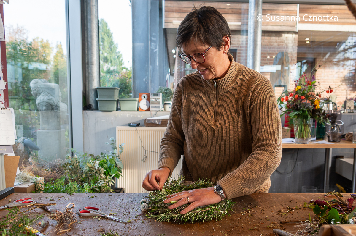 Eine Floristin arbeitet an einem Kranz Eine Floristin arbeitet an einem Kranz