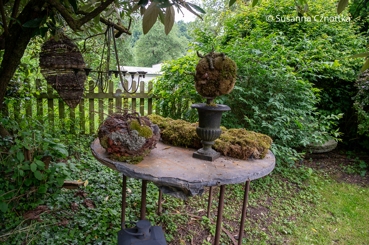 Florale Gartendekorationen mit Moos, Zweigen und anderem Naturmaterial