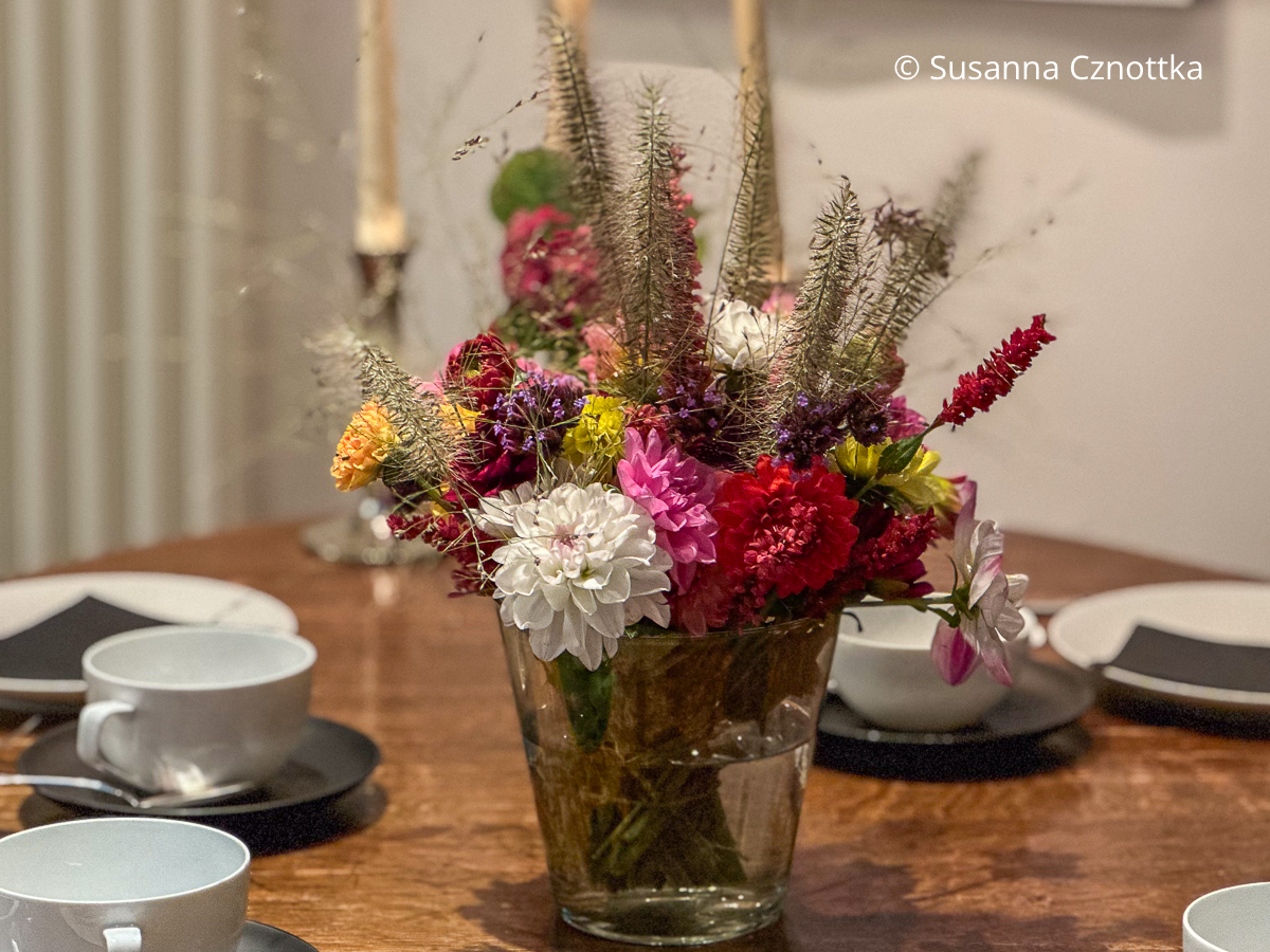Ein bunter Strauß mit Dahlien und Gräsern Ein bunter Strauß mit weißen, roten und pinken Dahlien und Gräsern auf einer schlichten Kaffeetafel