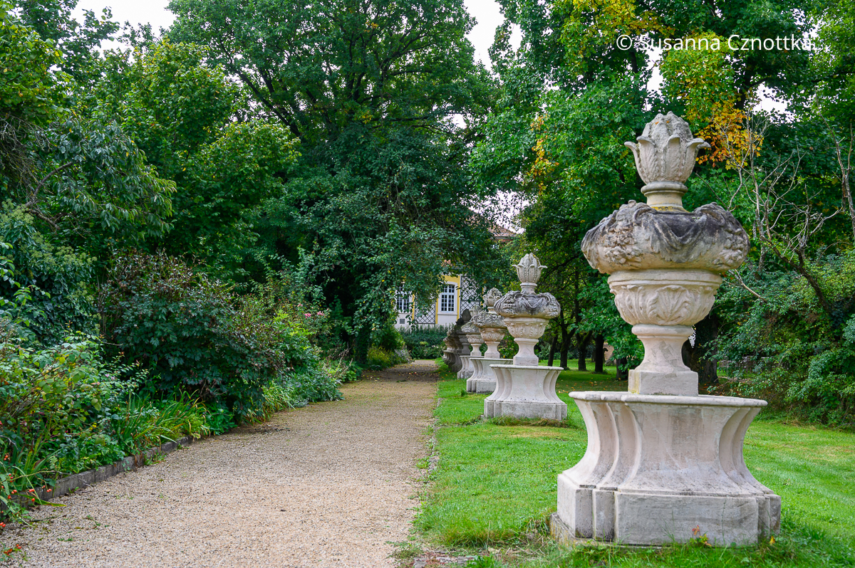 Sichtachse: Hohe Gartenvasen im barocken Stil betonen die Perspektive.