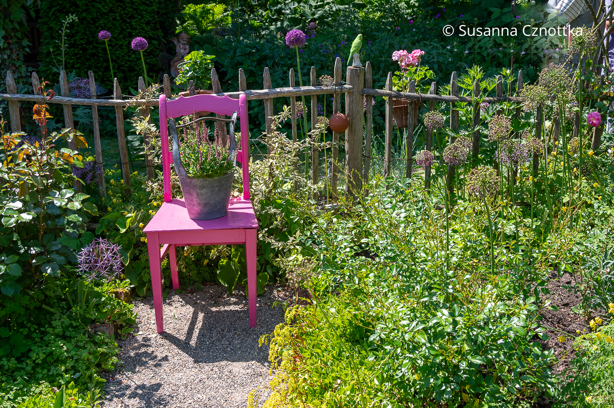 Detail im Bauerngarten: ein pinker Stuhl
