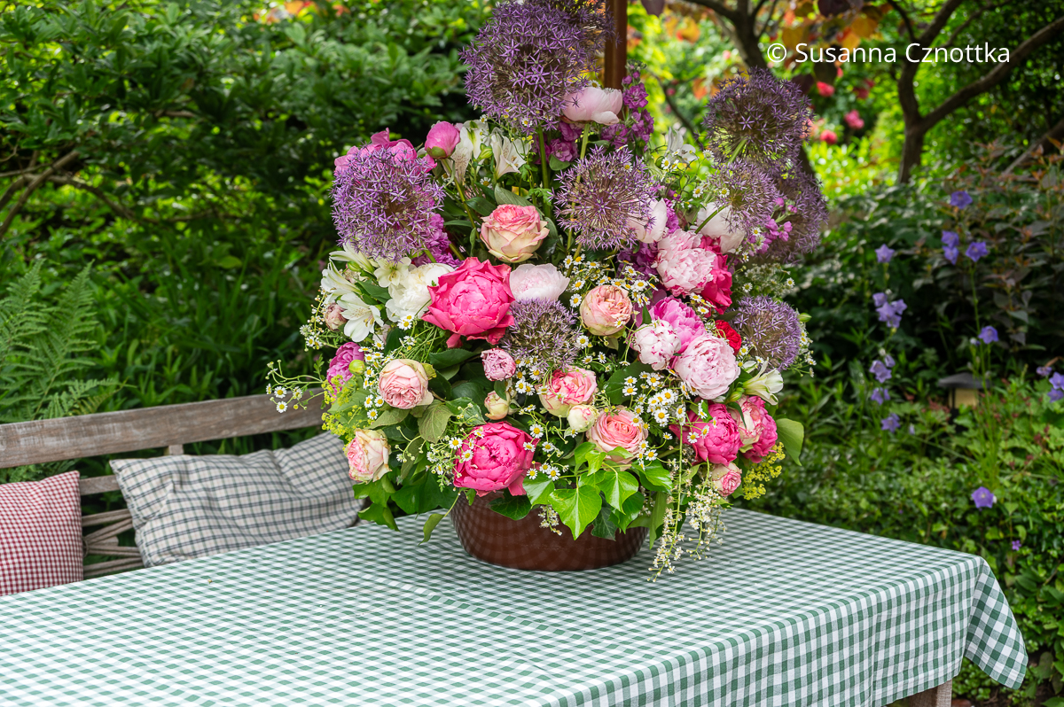 Üppiger Blumenstrauß mit pinken Rosen, Pfingstrosen und violetten Zierlauchblüten