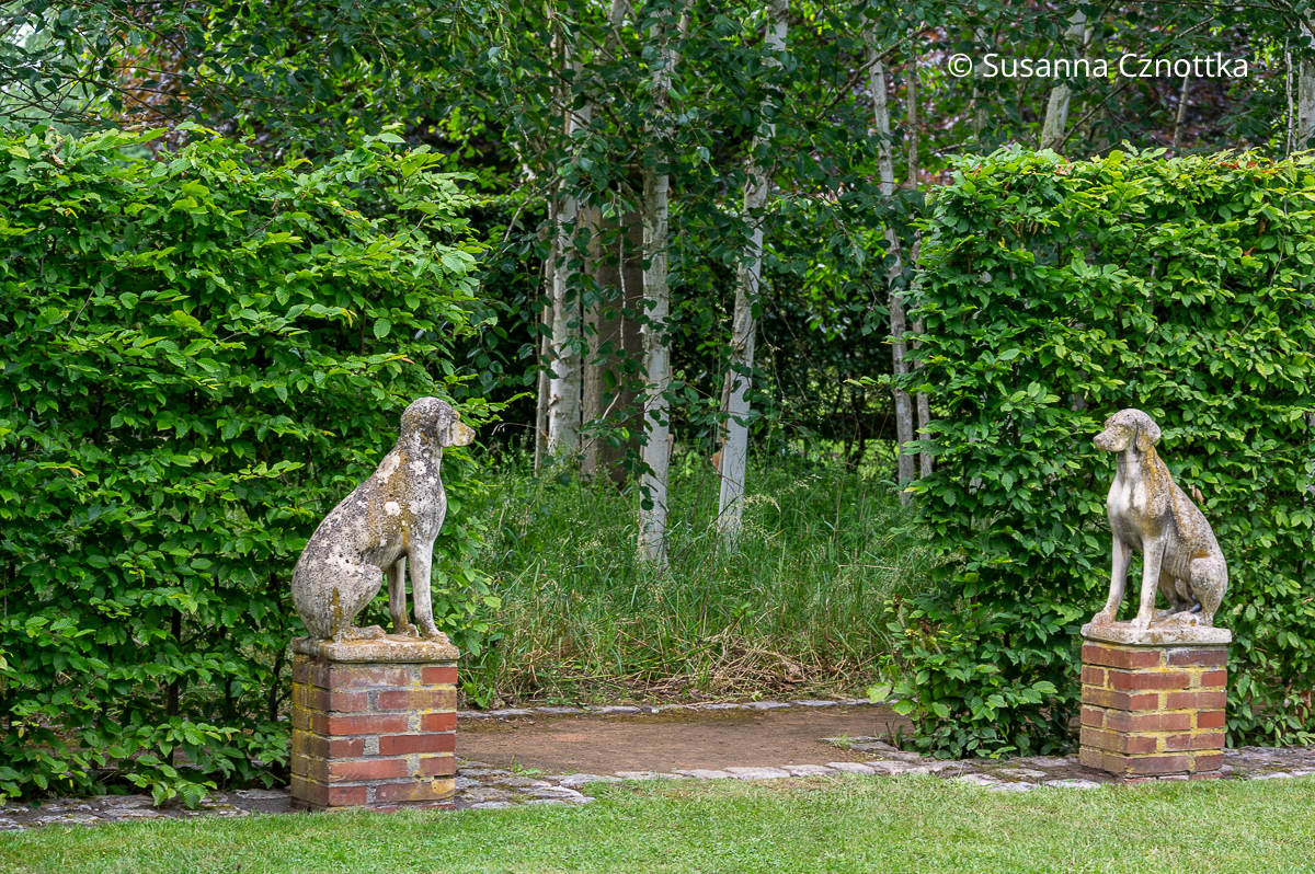 Steinerne Hunde am Übergang zwischen zwei Gartenräumen