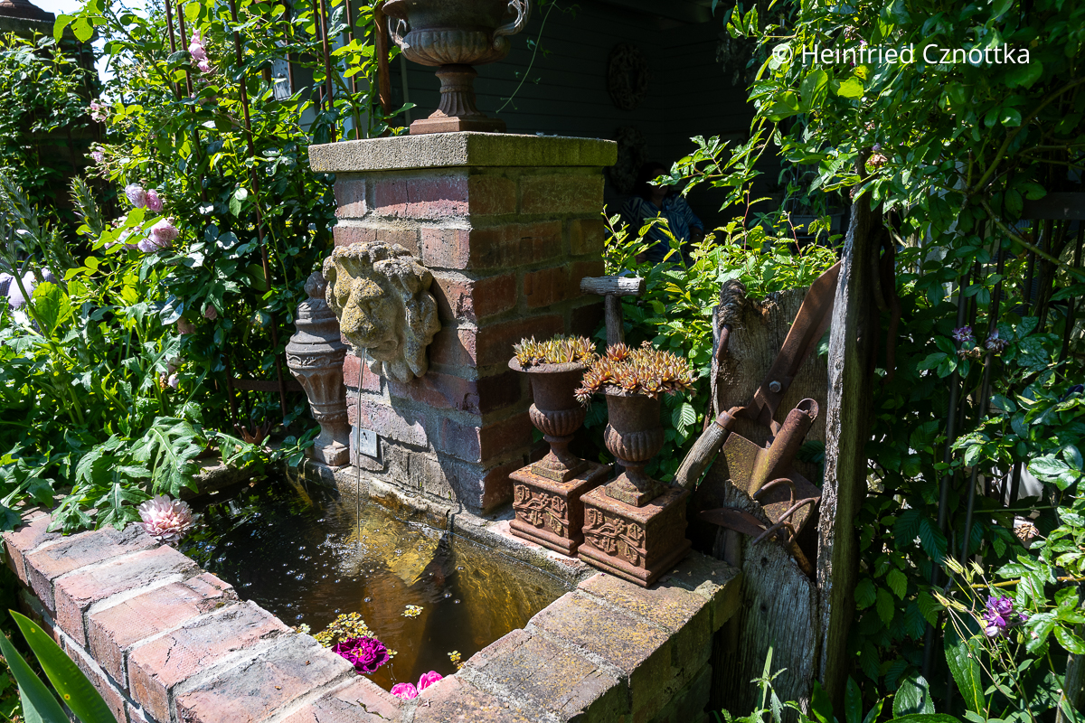 Ein gemauerter Brunnen mit einem Löwenkopf als Wasserspeier Ein gemauerter Brunnen mit einem Löwenkopf als Wasserspeier