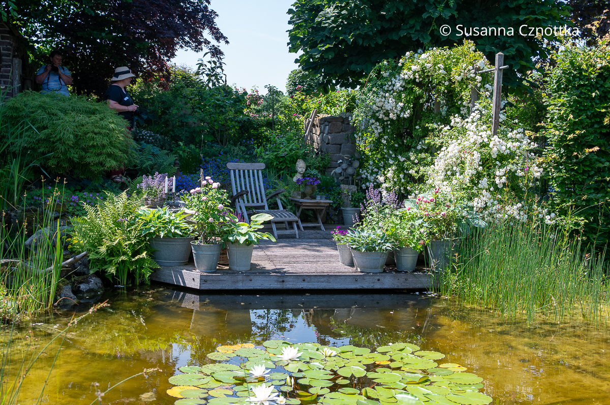 Ein Holzdeck mit Liegestuhl und Topfgarten im Garten Hommel-Althoff im Münsterland Ein Holzdeck mit Liegestuhl und Topfgarten im Garten Hommel-Althoff im Münsterland